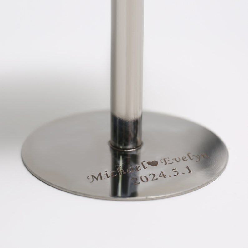 May include: A polished silver cake stand featuring a circular base and a central support. The base is engraved with the names "Michael Evelyn" and the date "2024.5.1". Ideal for presenting cakes or other treats at celebrations.