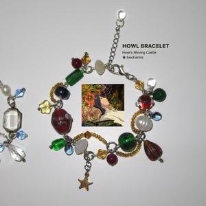 Op de afbeelding: Een kralenarmband met diverse kleurrijke kralen, waaronder rood, groen, geel en blauw. De armband heeft een kleine gouden sterbedel en een kleine afbeelding uit Howl's Moving Castle. De tekst "HOWL BRACELET" is zichtbaar.