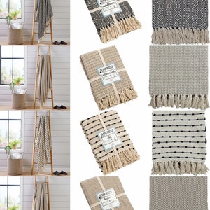 May include: Eight different throw blankets with fringe edges. The blankets are in various patterns and colours, including black, white, and beige. The blankets are all folded and displayed on a white background.