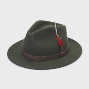 Peut inclure: Chapeau fedora vert fonc&eacute; avec un bandeau en cuir marron. Une plume rouge et blanche est attach&eacute;e sur le c&ocirc;t&eacute;. Le chapeau a un large bord et une couronne l&eacute;g&egrave;rement creus&eacute;e.
