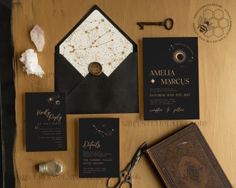 May include: Black and gold wedding invitation suite with a celestial theme. The invitation features a crescent moon and stars, while the RSVP card has a constellation design. The details card includes the text "Amelia Marcus" and "Saturday 16th July 2023".