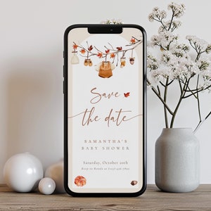 May include: A digital save the date card for a baby shower with a fall theme. The card features a branch with leaves and baby clothes hanging from it. The text reads "Save the date" and "Samantha's Baby Shower". The date is Saturday, October 20th. The RSVP number is (123)-456-7890.