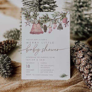 Rustic winter baby shower invitation with watercolor greenery, ornaments, and baby dress illustration. Neutral holiday theme invitation template