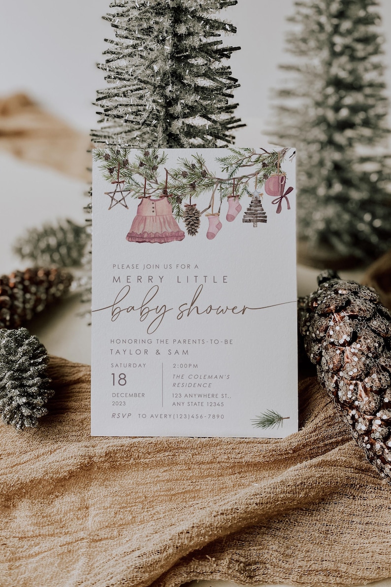 Rustic winter baby shower invitation with watercolor greenery, ornaments, and baby dress illustration. Neutral holiday theme invitation template