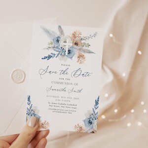 Pode incluir: Um cartão Save the Date para uma comunhão, com um design floral com detalhes em azul e bege. O cartão inclui o texto "Save the Date para a Comunhão de Samantha Smith" e detalhes do evento. Uma envelope com um selo de cera também está presente.