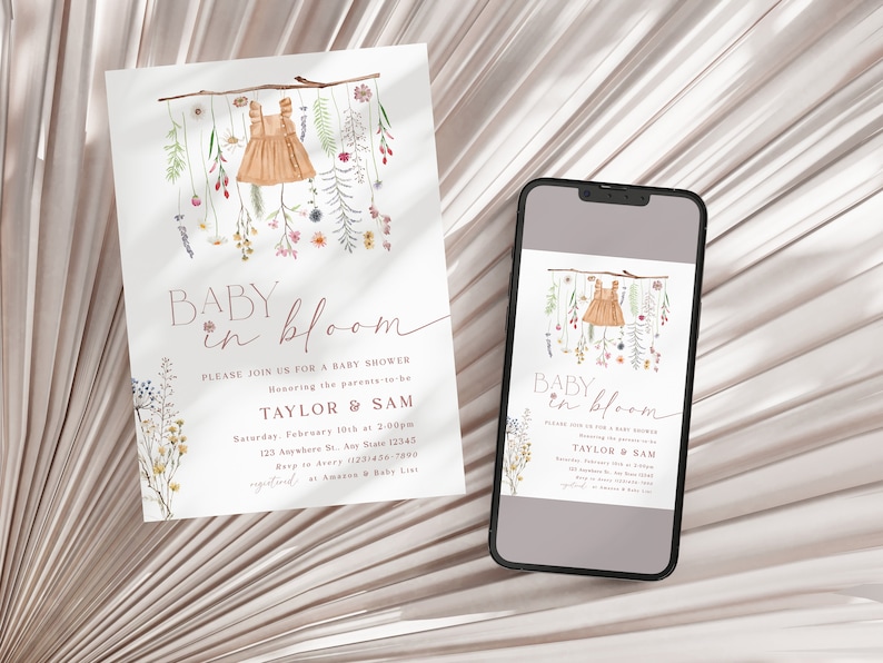 May include: A baby shower invitation featuring a watercolour illustration of a baby dress hanging from a branch with flowers. The text reads "Baby in Bloom" and includes the names "Taylor & Sam" and the date and time of the shower.