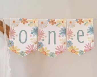 Op de afbeelding: Een bloemenbanner met het woord "one" in lichtblauwe letters. De banner is versierd met pastelkleurige bloemen en een witte achtergrond.