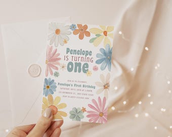 May include: A colorful floral birthday invitation with the text "Penelope is turning one" in a blue and green font. The invitation is decorated with watercolor flowers in shades of pink, blue, yellow, and green.