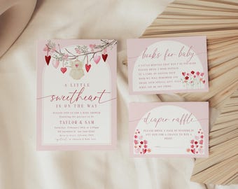 May include: A pink and white baby shower invitation with a watercolor illustration of a heart-shaped mobile with a baby doll hanging from it. The text reads "A little sweetheart is on the way". There are also two additional cards for a diaper raffle and a book request for the baby.