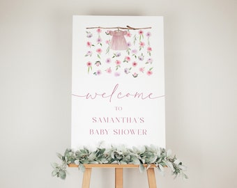 May include: Welcome to Samantha's Baby Shower sign featuring a pink baby dress hanging from a branch with pink and purple flowers.