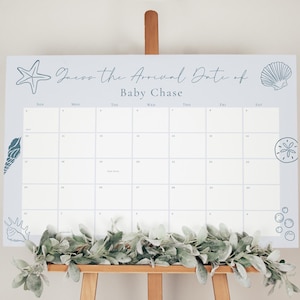 May include: A pale blue baby shower calendar with the text "Guess the Arrival Date of Baby Chase." The calendar features sea-themed illustrations, such as a starfish, seashells, and bubbles. A garland of green leaves decorates the bottom.
