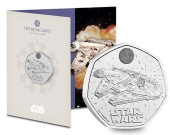 May include: A silver coin featuring a line drawing of the Millennium Falcon from Star Wars. The coin is a 50 pence piece and has the words "Star Wars" on it.