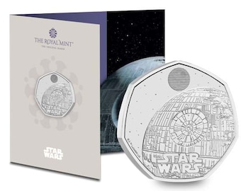 May include: A silver coin featuring the Death Star from Star Wars. The coin is a 50 pence piece and is part of the Royal Mint's Star Wars collection.