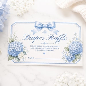 Op de afbeelding: Een baby shower luier verloting kaart met een lichtblauwe strik en bloemaccenten. De kaart leest "Diaper Raffle" en bevat instructies voor deelname. Blauwe hortensia's en witte bloemen versieren de kaart.