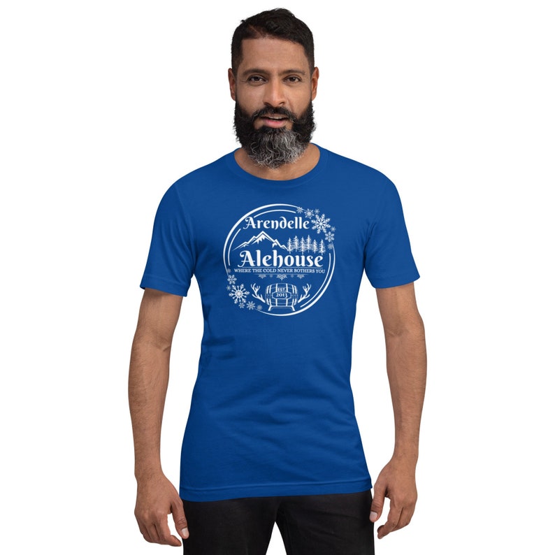 May include: A royal blue t-shirt with a white graphic of a mountain scene and the text "Arendelle Alehouse, Where the cold never bothers you".