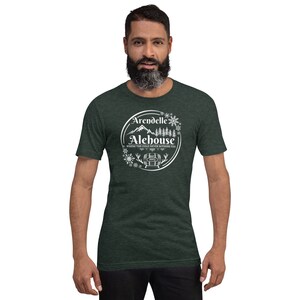 May include: A dark green t-shirt with a white circle design featuring the text "Arendelle Alehouse" and the words "Where the cold never bothers you".