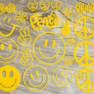 Könnte beinhalten: Gelbe Ausstanzungen von Smiley-Gesichtern, Friedenszeichen, Blumen und dem Wort "PEACE" in einer coolen Schriftart. Die Formen sind auf einem hellen Holzmaserungshintergrund angeordnet und erzeugen eine fröhliche und Retro-Atmosphäre.