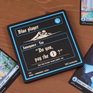May include: A black card with blue trim and text that reads "Blue player" and "Do you, pay the 1?". The card is surrounded by other cards with landscape illustrations and the text "Basic Land - Island".