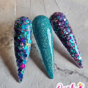 May include: Three different nail dip colors, one is a teal blue with glitter, one is a light blue with glitter, and one is a purple with pink and blue glitter.