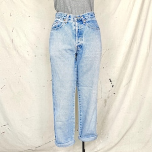 Könnte beinhalten: Hellblaue Jeans im Acid-Wash-Look mit hoher Taille und Knopfleiste. Die Jeans hat ein gerades Bein und ist an den Knöcheln umgeschlagen. Die Jeans wird auf einer Schaufensterpuppe präsentiert.