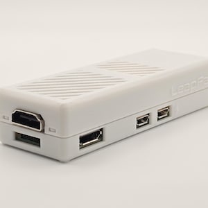 May include: White rectangular device with a textured top and the text "LeapGate" printed on the side. The device has an HDMI port, a micro USB port, and two USB ports.