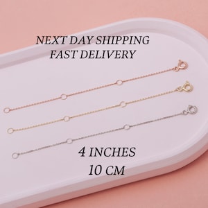 May include: Three gold chain extenders in different colors: rose gold, yellow gold, and silver. Each extender is 4 inches (10 cm) long and has a lobster clasp.