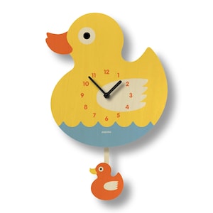 Puede incluir: Un reloj de pared con forma de pato amarillo, con un pico naranja y un pequeño péndulo de pato naranja. La esfera del reloj tiene manecillas y números negros. La parte inferior tiene un diseño de olas azules. La marca "poplox" está impresa en la parte inferior.
