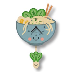 Puede incluir: Un reloj de pared caprichoso con forma de cuenco de ramen. La esfera del reloj es azul claro con una cara sonriente, fideos, huevos y verduras verdes. El péndulo es una verdura verde con una cara sonriente. Las manecillas del reloj son negras.