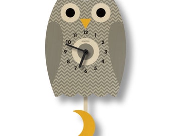 May include: A gray owl-shaped clock with a chevron pattern and a yellow beak. The clock has black hands and a white face with black numbers. The clock has a yellow crescent moon pendulum.
