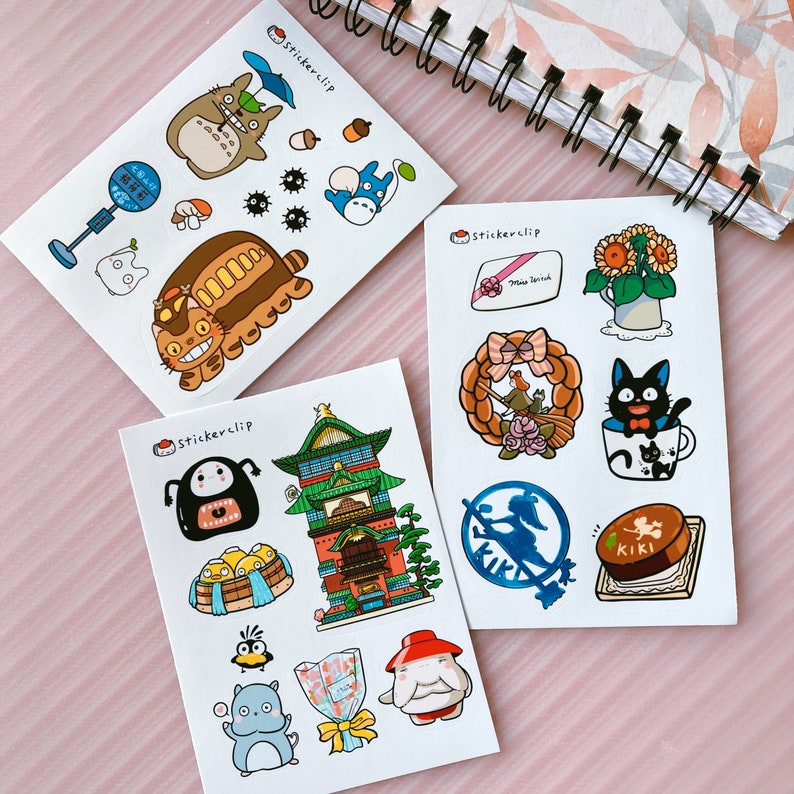 May include: Three sheets of stickers featuring characters and scenes from the Studio Ghibli films 'My Neighbor Totoro', 'Kiki's Delivery Service', and 'Spirited Away'. The stickers are printed on white paper with a glossy finish. The stickers are packaged in a clear plastic sleeve.
