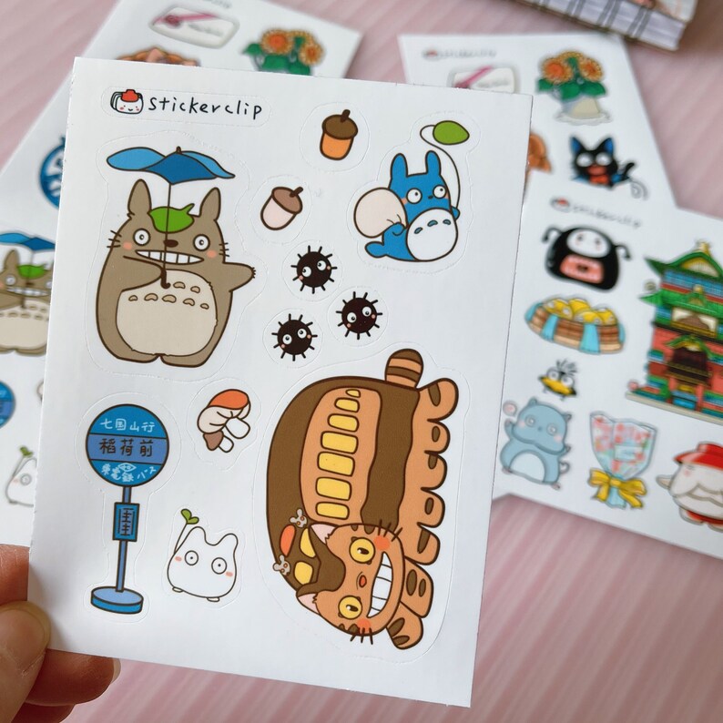 May include: A sheet of stickers featuring characters from the animated film My Neighbor Totoro. The stickers are on a white background and include Totoro, Catbus, and other characters. The stickers are perfect for adding a touch of whimsy to your planner, laptop, or water bottle.