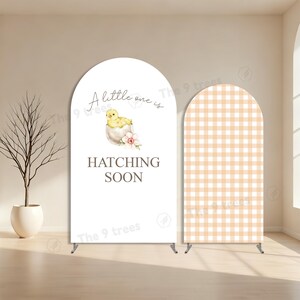 May include: Two arched backdrop covers. The left cover is white with a watercolour illustration of a yellow chick in an eggshell, pink flowers, and the text A little one is HATCHING SOON. The right cover features a light orange and white gingham pattern.