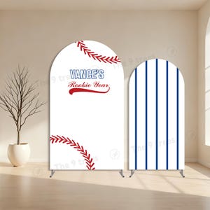 May include: Two arched backdrops with a baseball theme. One has a baseball design with red stitching and the text "Vance's Rookie Year." The other has blue vertical stripes. Both stand on metal supports.