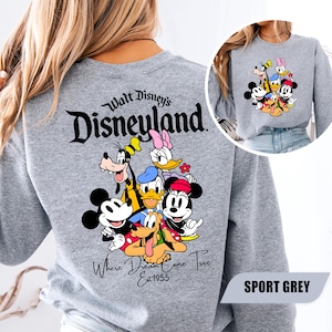 May include: A sport grey long-sleeve sweatshirt featuring a large graphic on the back of Mickey Mouse, Minnie Mouse, Donald Duck, Daisy Duck, Goofy, and Pluto. The text reads Walt Disney's Disneyland Where Dreams Come True Est 1955.