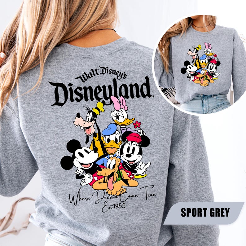 May include: A sport grey long-sleeve sweatshirt featuring a large graphic on the back of Mickey Mouse, Minnie Mouse, Donald Duck, Daisy Duck, Goofy, and Pluto. The text reads Walt Disney's Disneyland Where Dreams Come True Est 1955.