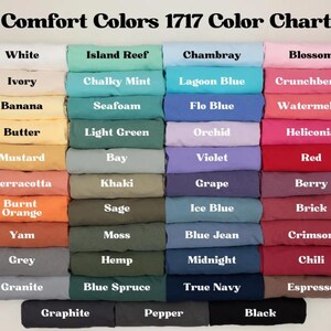 Op de afbeelding: Een kleurenkaart getiteld "Comfort Colors 1717 Color Chart" toont een verscheidenheid aan stoffen kleuren. De kaart bevat tinten zoals wit, ivoor, banaan, boter, mosterd, terracotta, verbrand oranje, yam, grijs en graniet.