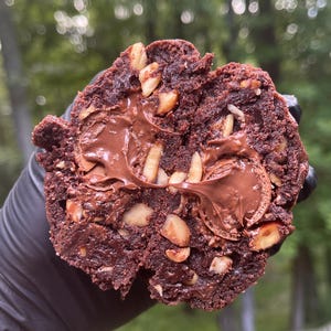 May include: A chocolate chip cookie with hazelnut pieces and a chocolate spread filling.