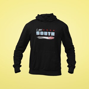 以下が含まれることがあります： 黒いフード付きスウェットシャツに「i am SOUTH side」という文字が青と赤で書かれています。