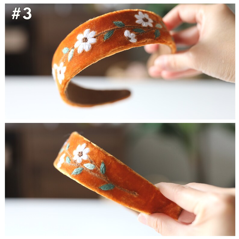 May include: A brown velvet headband with white embroidered flowers and green leaves.