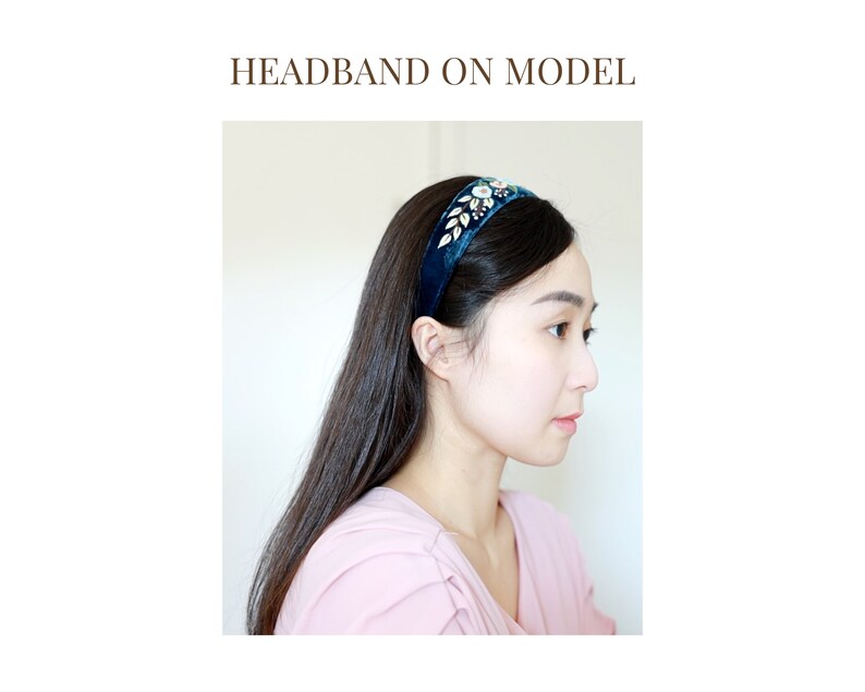 May include: A dark blue velvet headband with a gold and clear rhinestone embellishment. The headband is worn by a model with long dark hair.