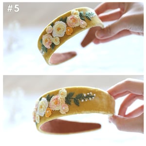 May include: A mustard yellow velvet headband with embroidered white, pink, and orange flowers and green leaves.
