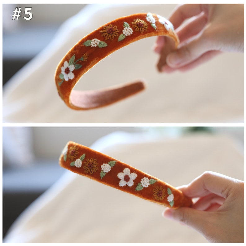 May include: A brown velvet headband with embroidered white flowers and yellow centers. The headband is decorated with green leaves.