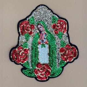 May include: Embroidered patch featuring an image of the Virgin Mary, surrounded by red sequined roses and green and silver sequined accents. The patch has a black border and is likely for clothing or accessories.
