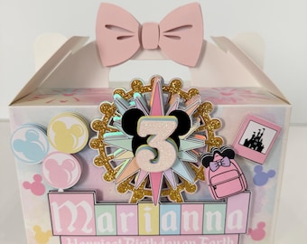May include: A decorative birthday gift box with a pink bow on top. The box is decorated with a gold and black Mickey Mouse-themed design, the number 3, and the name "Marianna". The text "Happiest Birthday on Earth" is also visible.