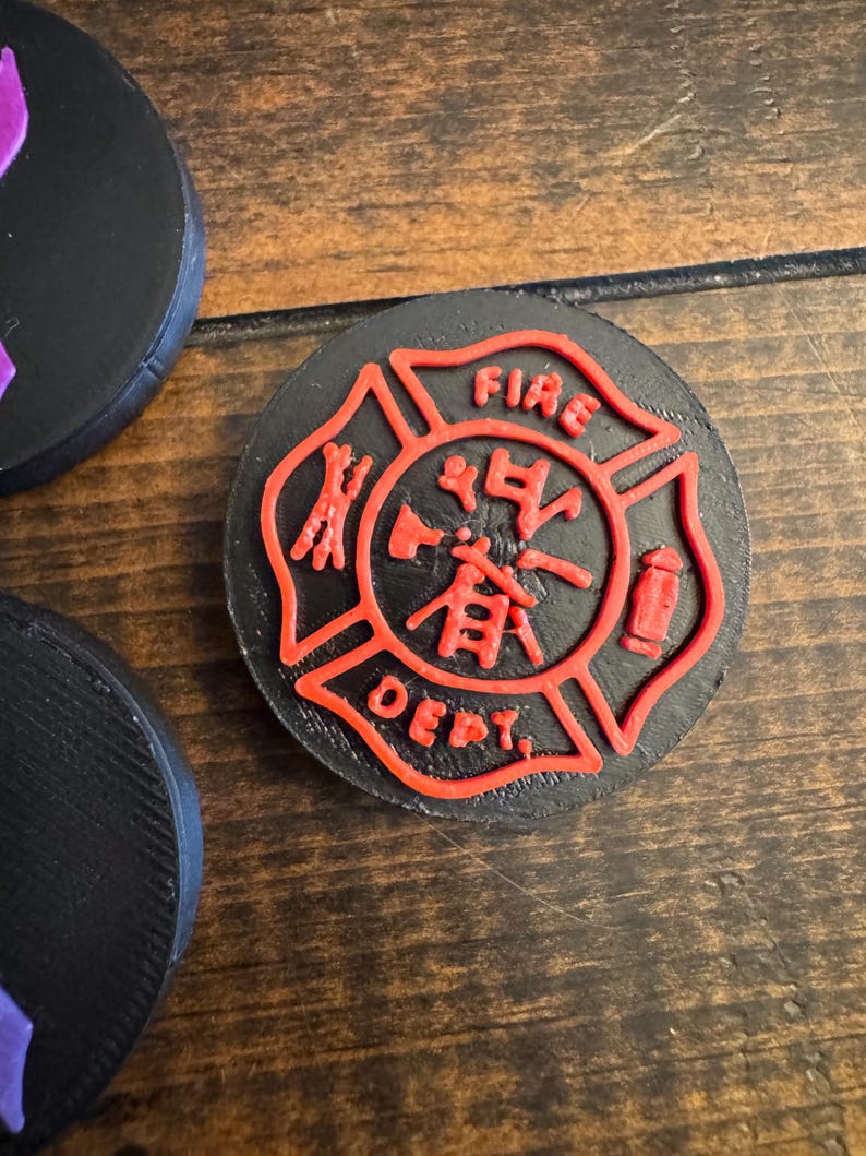 May include: Black, round coaster with a red fire department emblem. The emblem features the words "FIRE DEPT." and Chinese characters. The coaster is made of a solid material and is likely for use in a home or office setting.