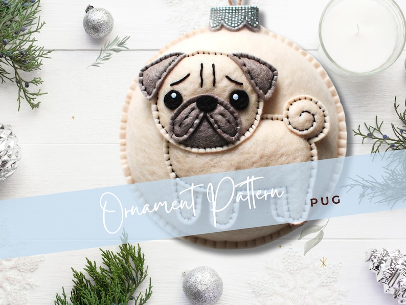 Może przedstawiać: Wz&oacute;r na choinkową ozdobę z filcu przedstawiający psa rasy mops. Wz&oacute;r jest przeznaczony dla okrągłej ozdoby z beżowym filcowym ciałem i szarymi filcowymi cechami twarzy. Tekst "Ornament Pattern PUG" jest nadrukowany na niebieskim tle.
