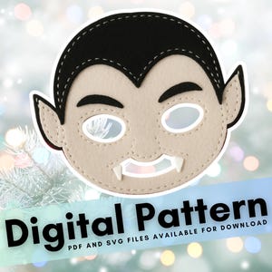 May include: A felt vampire mask with black hair, pointed ears, and white fangs. The mask has eye holes and is stitched around the edges. Text at the bottom reads "Digital Pattern".