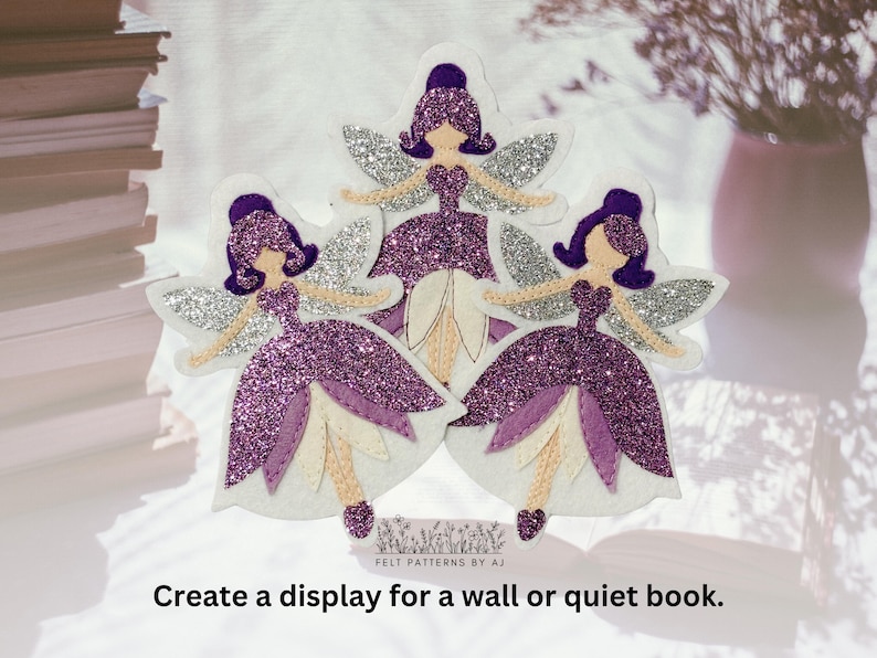 Pu&ograve; includere: Tre figure di fate in feltro viola con ali di glitter argentate e accenti di fiori bianchi. Le fate sono disposte a forma di triangolo su uno sfondo bianco. Il testo "FELT PATTERNS BY AJ" &egrave; visibile nella parte inferiore dell'immagine.