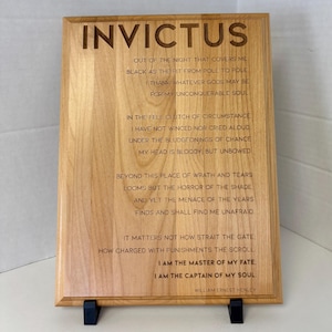 May include: A wooden plaque with the poem "Invictus" by William Ernest Henley engraved on it. The poem is about resilience and overcoming adversity.