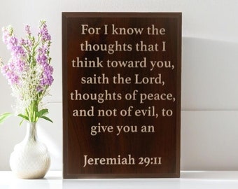 May include: A wooden sign with a brown background and white text. The text reads "For I know the thoughts that I think toward you, saith the Lord, thoughts of peace, and not of evil, to give you an Jeremiah 29:11".